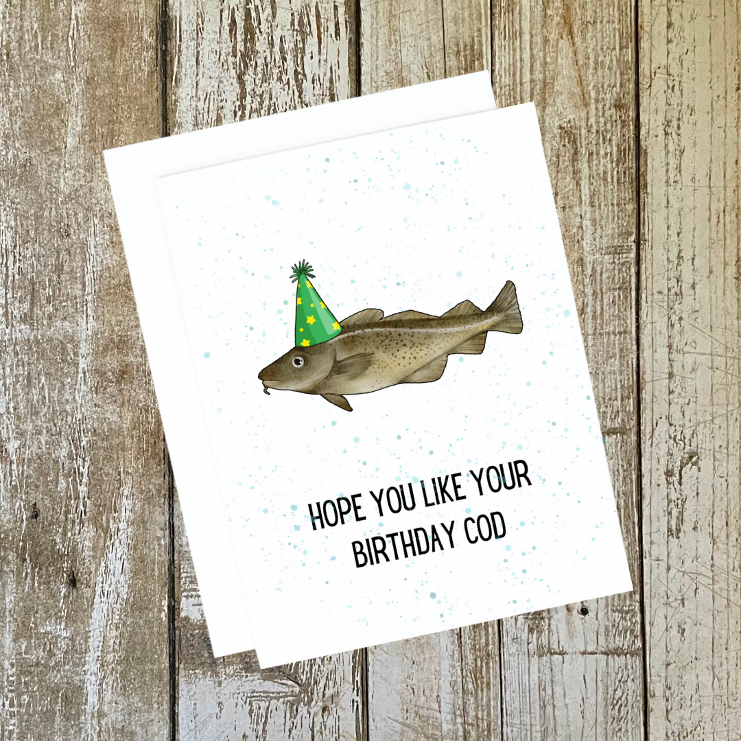 A photo of a white birthday card. It has an illustration of a fish in a party hat. Text reads, hope you like your birthday cod.