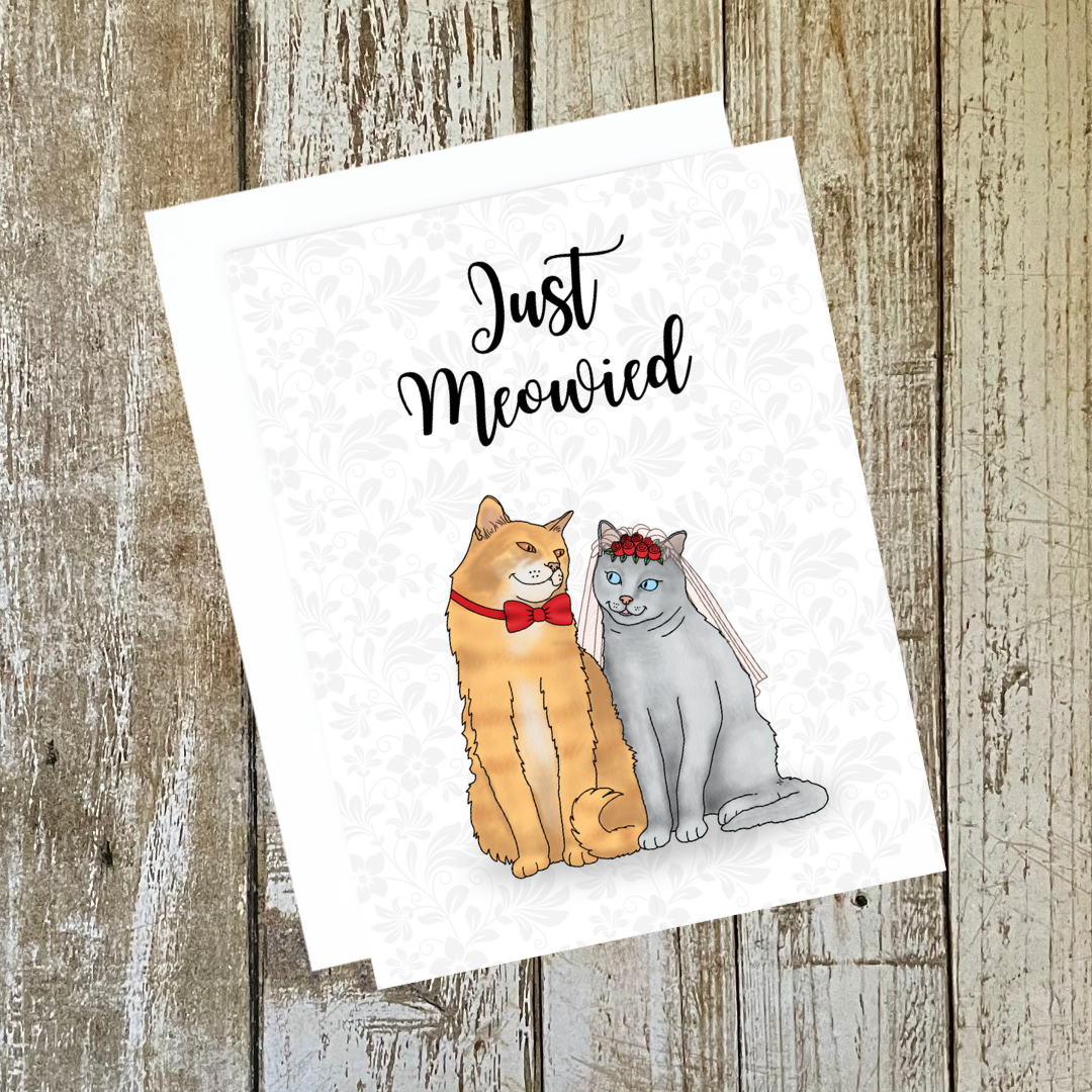 A photo of a wedding card. It has two cats in wedding garb. Text reads, Just Meowied.