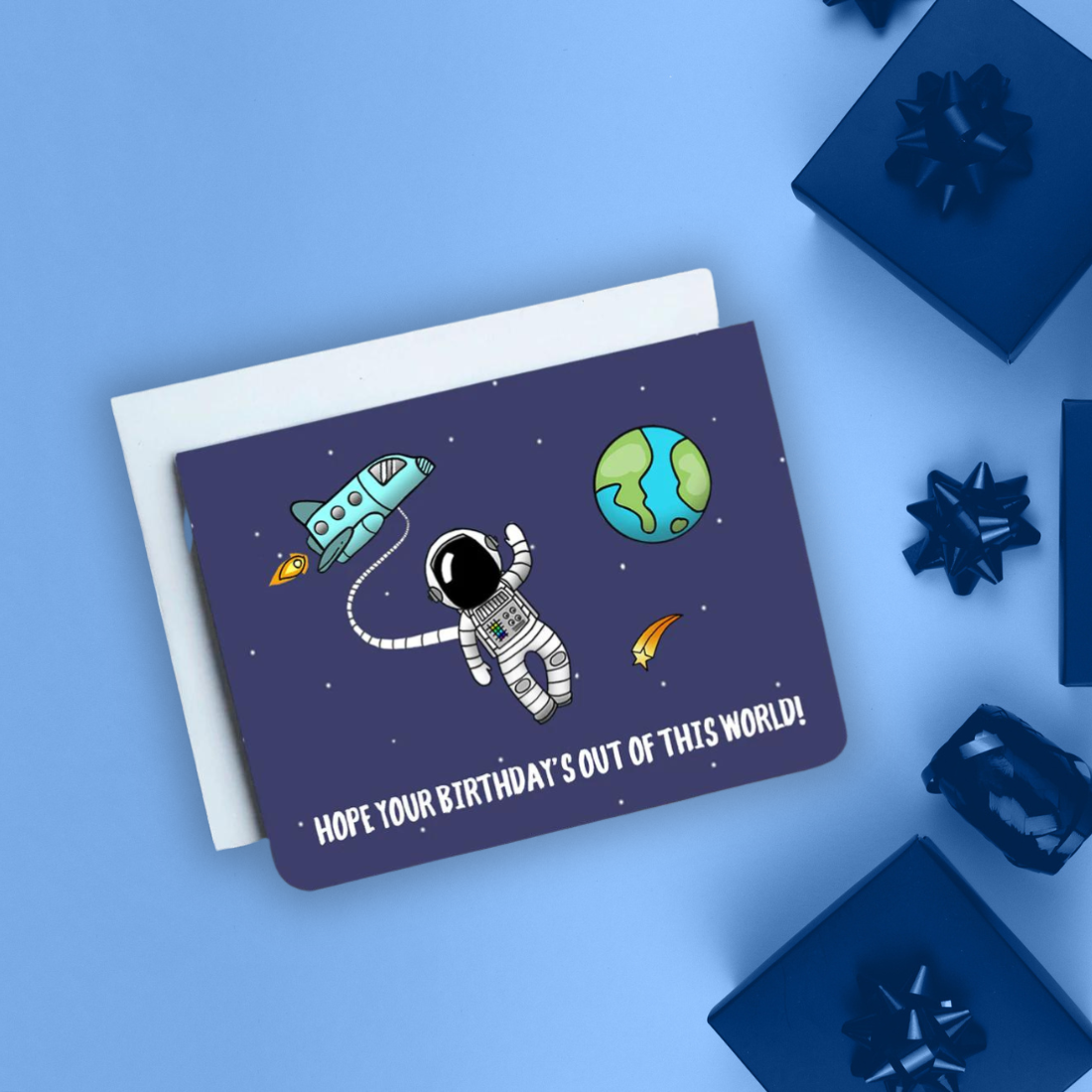 A photo of a dark blue birthday card. It has a cartoon astronaut on it with a cartoon earth behind. Text on card reads, 'Hope Your Birthday's Out of This World!'