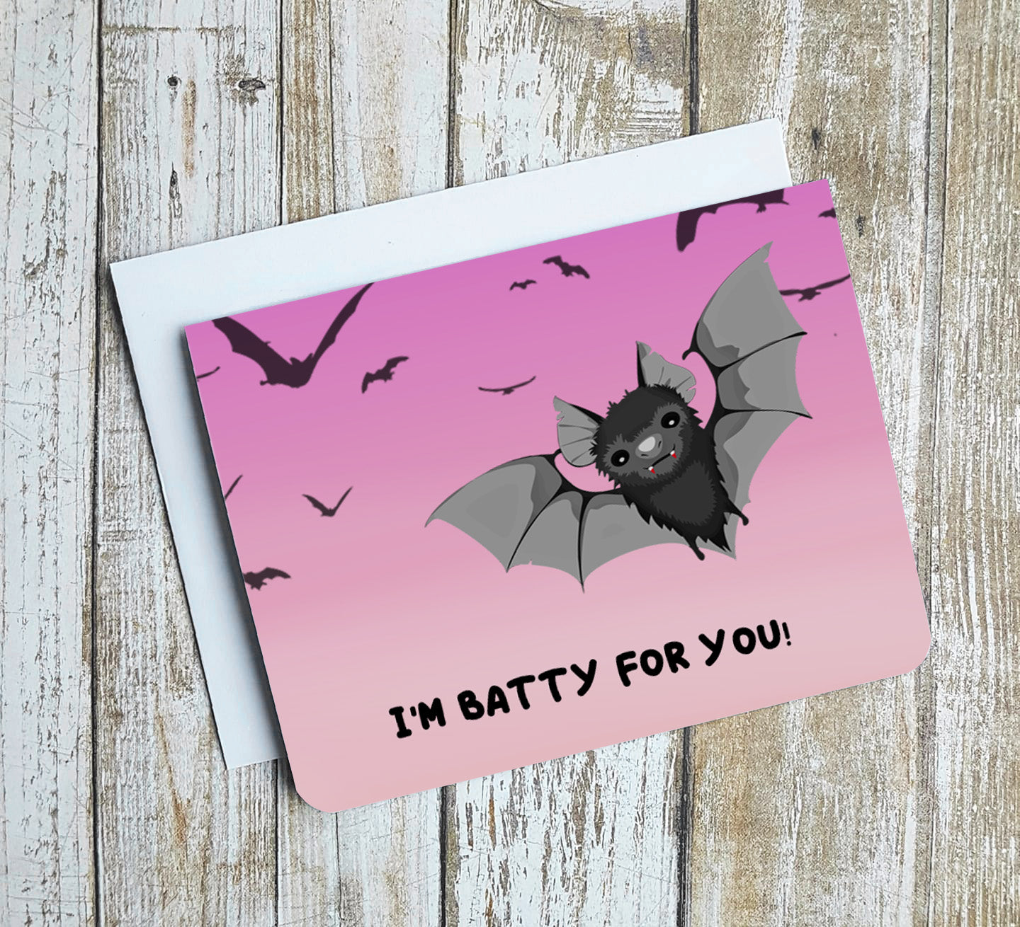 A photo of a pink valentines card with a cartoon bat on it. Text on card reads 'I'm batty for you!'